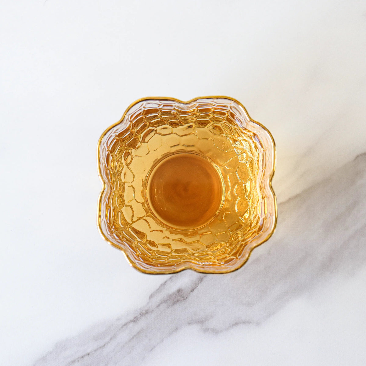 Brewed Da Hong Pao Oolong Tea liquor in an amber glass bowl from above.