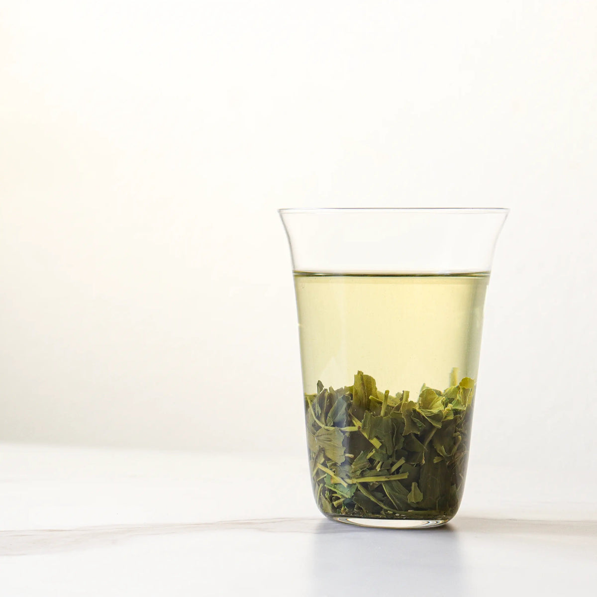 Enshi Yulu Green Tea brewed in a clear glass with leaves settled at the bottom