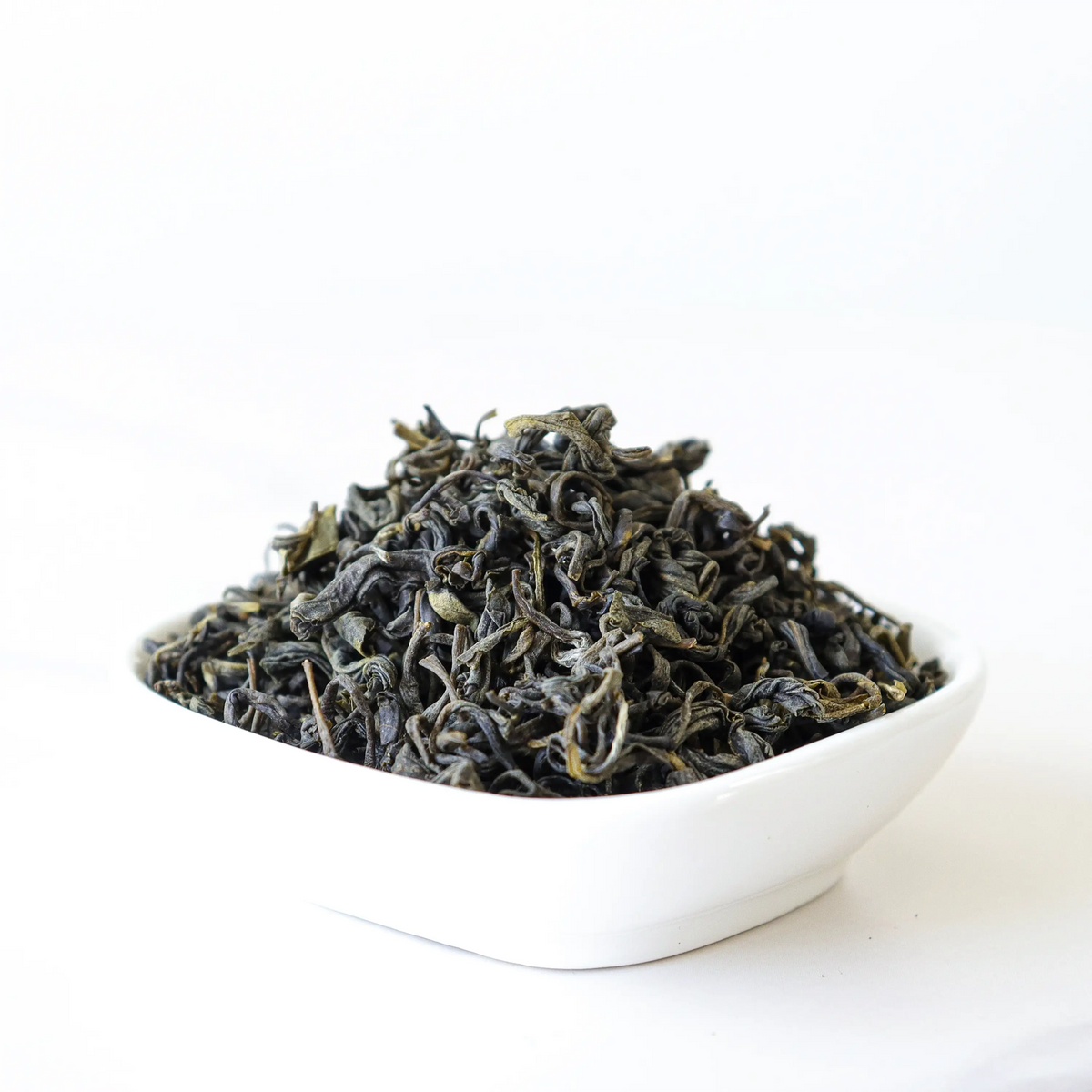 Gardenia Green Tea loose leaf blend in a white square bowl