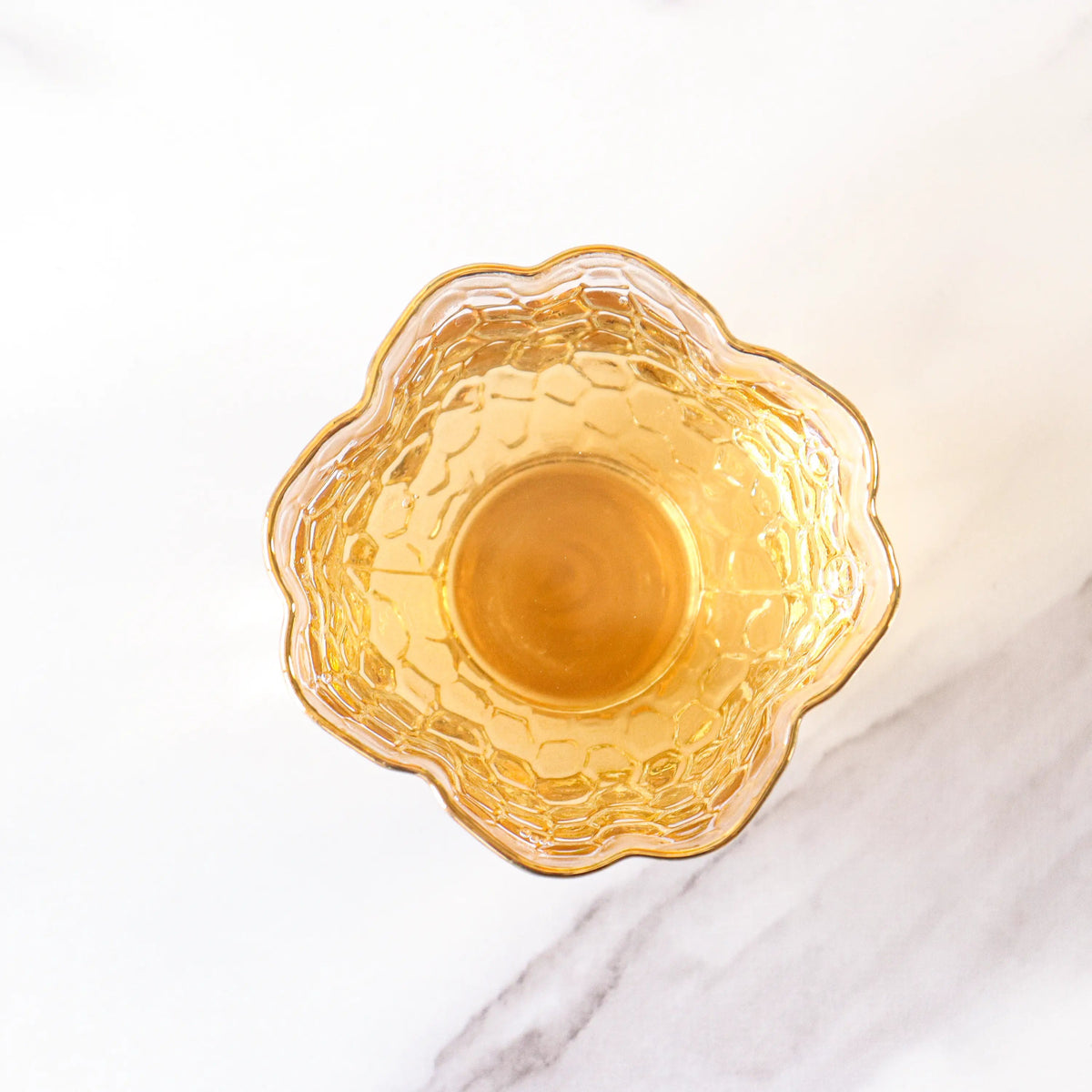 Brewed Keemun Black Tea liquor in an amber glass bowl from above.