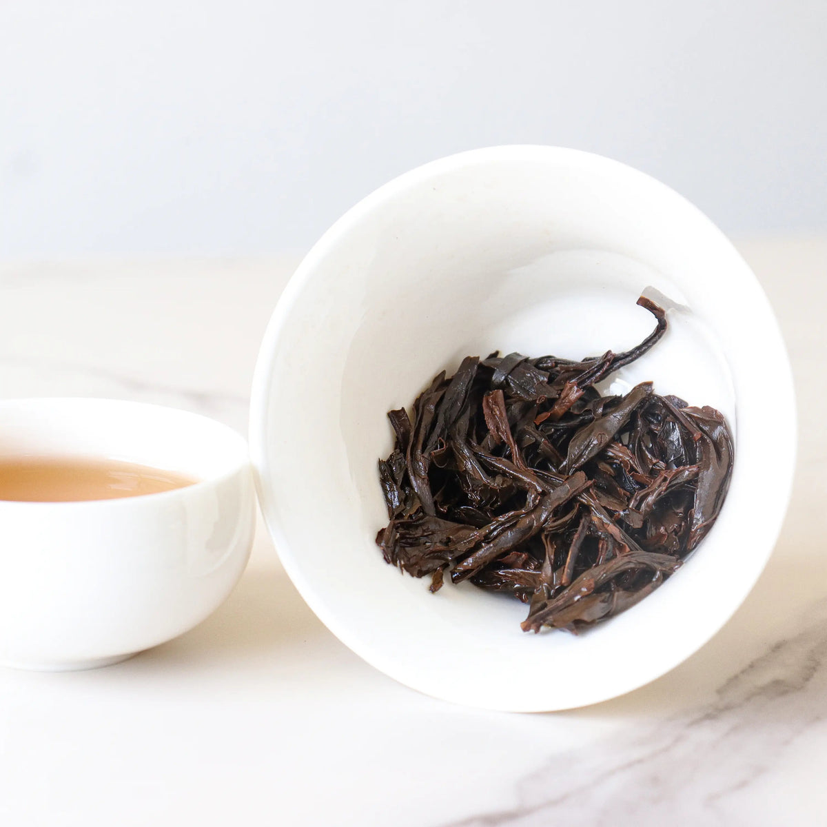 Clear brewed cup of Lapsang Souchong Black Tea showing the tea liquor color.
