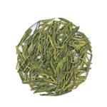 My Store’s Longjing Dragon Well Green Tea leaves are arranged in a circle on a white background, showcasing their distinctive chestnut aroma.