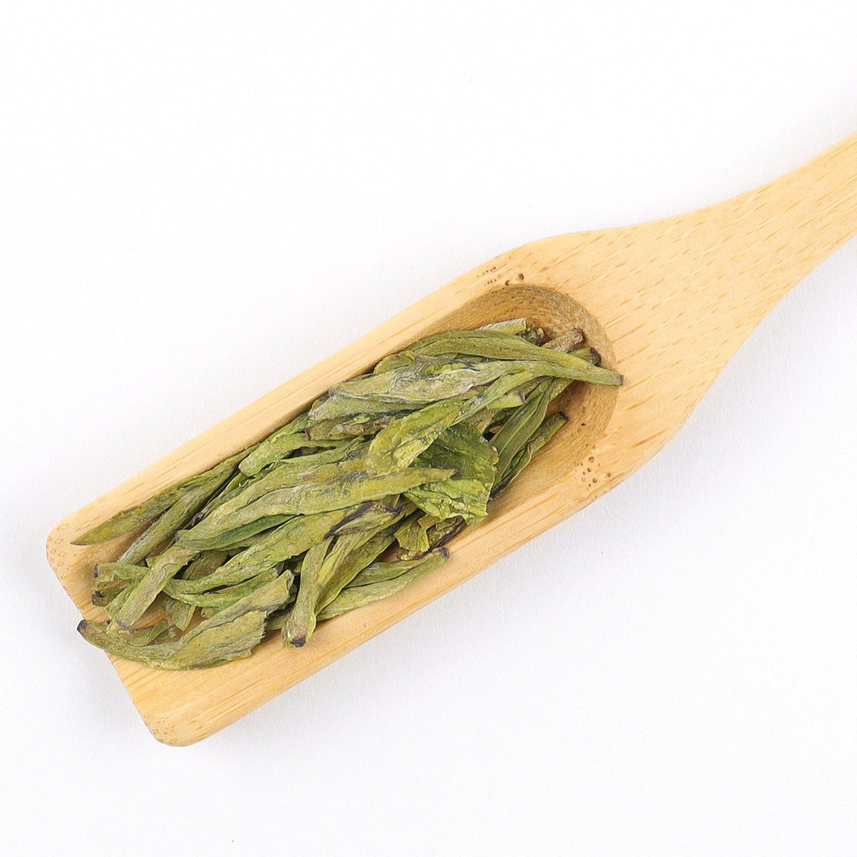 Premium West Lake Longjing Tea flat green leaves in a wooden scoop.