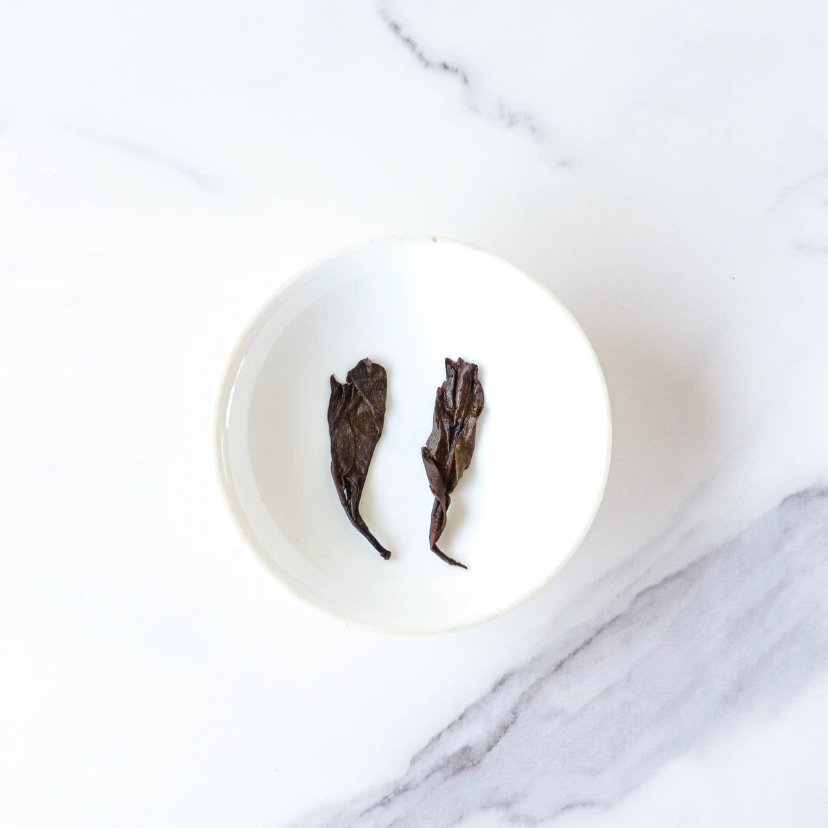 CHICHATEA Ripened Pu-erh loose tea leaves in a small white bowl