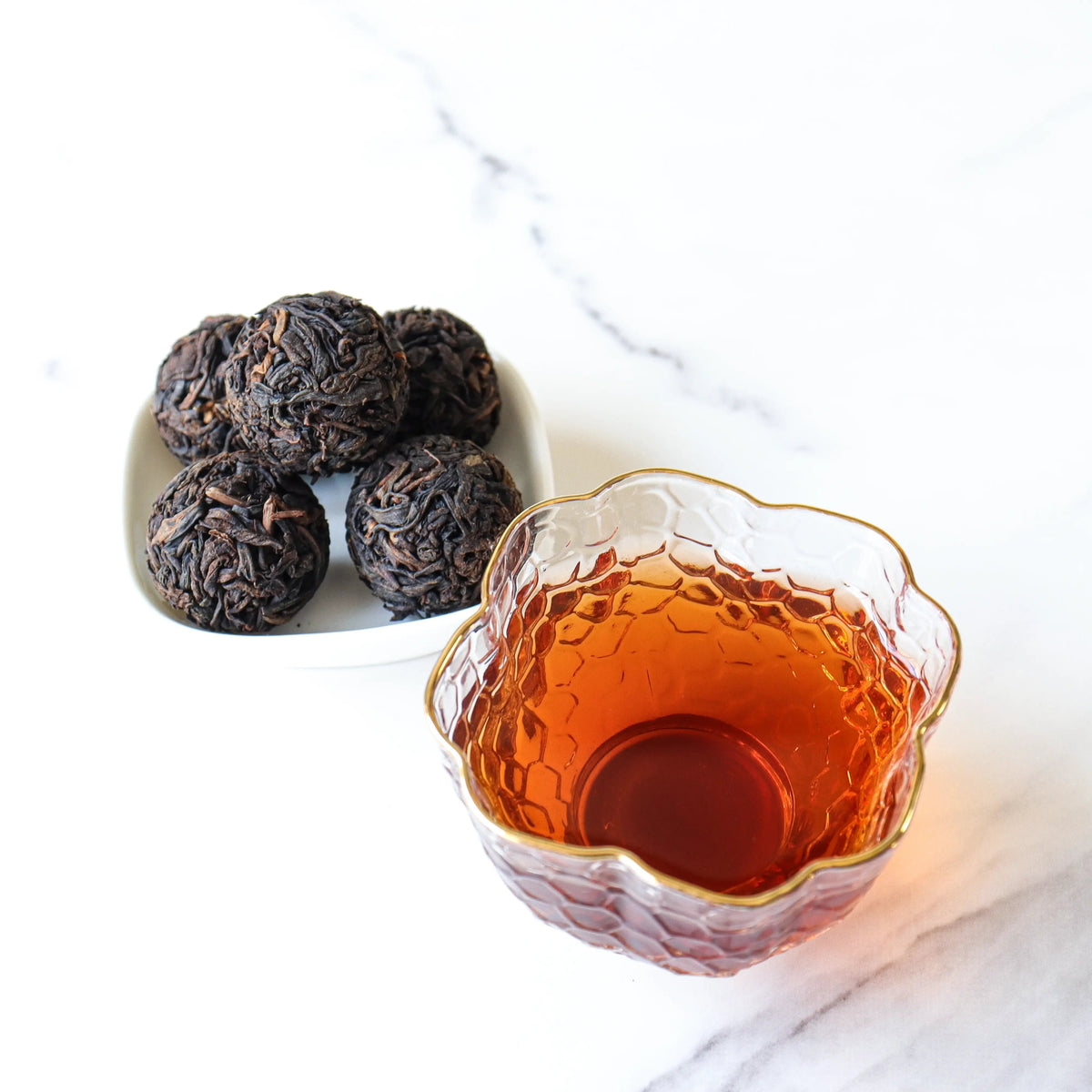 CHICHATEA Ripened Pu-erh Tea Pearls beside amber brewed tea