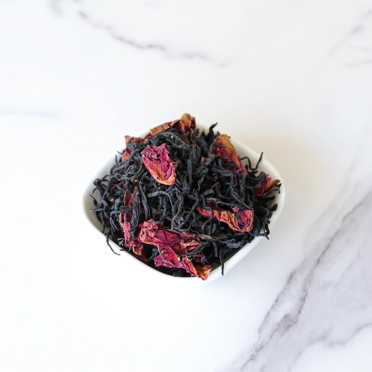 CHICHATEA Rose Black Tea blend with loose black tea leaves and dried rose petals in a white bowl