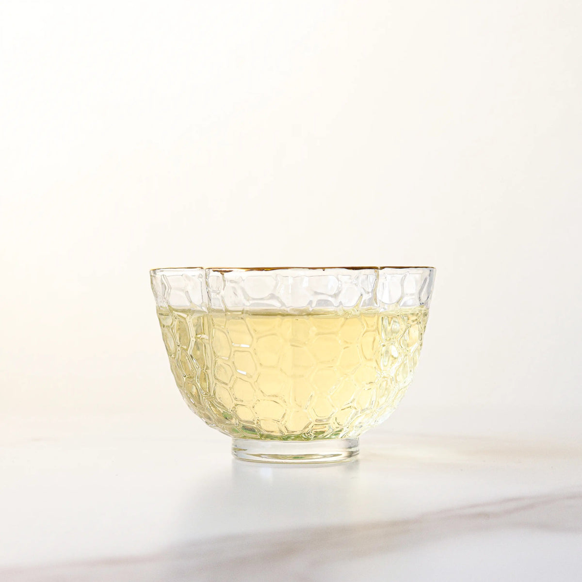 Light yellow Zhu Ye Qing Green Tea liquor in a clear glass cup